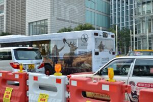 A deer appears in the middle of traffic, and a man from the wilderness seems to have stepped off the trail to hail a cab. The scene holds just long enough to feel plausible within the rhythm of the city. Then it resolves itself. Just an advertisement for an outdoor clothing company, promoting a return to nature. In Hong Kong, even this feels natural, where the imagined and the real pass through each other without resistance.